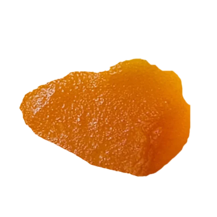 Close-up overhead view of a glossy amber shard of Blue Dream Live Resin against a white background.
