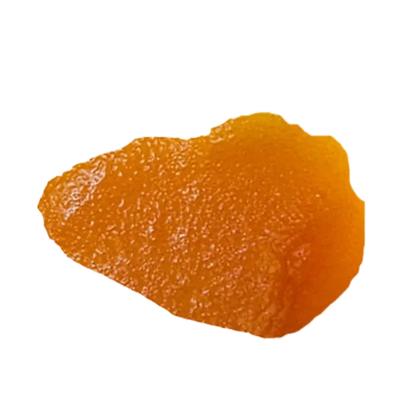 Close-up overhead view of a glossy amber shard of Blue Dream Live Resin against a white background.